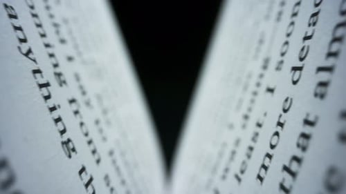 Open book pages turning, macro view of text