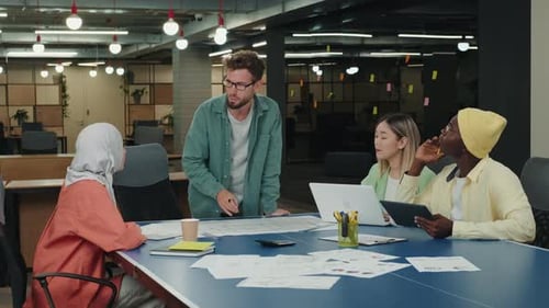 Diverse Team Collaborates on Project in Modern Office