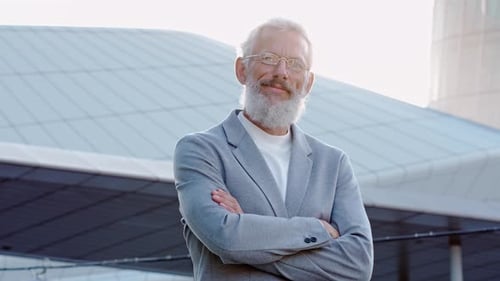 Confident Man with Gray Beard Stands Outside Smiling