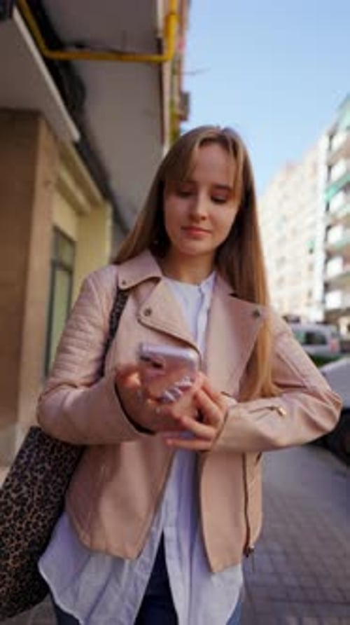 Confident Young Professional Navigating City Street Scrolling Smartphone Screen and Walking with