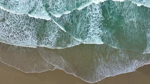 Tranquil Scenery Of The Beach With Ocean Waves Crashing On Shore - Aerial Top Down