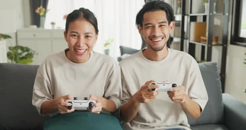 Enthusiastic Couple Plays Video Games at Home