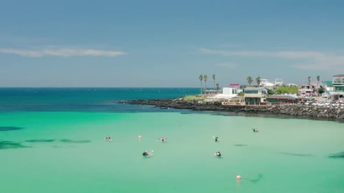 People kayaking in the crystal clear waters of Jeju Island.
