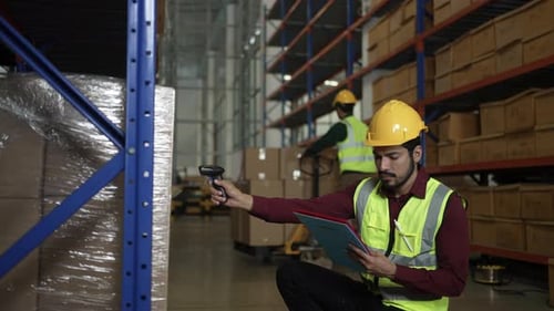 Blue collar workers are working at warehouse.