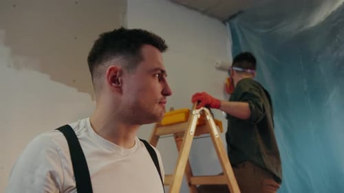 Close Up View of the Handsome House Painter with the Stain of White Paint on His Forehead Looking