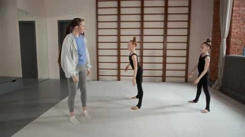 Schoolgirls Repeating New Exercise after Young Teacher or Instructor