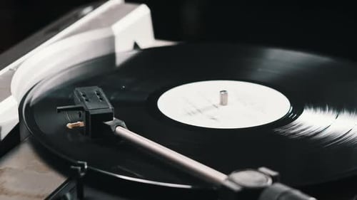 Hand Places Needle on Vinyl Record Player