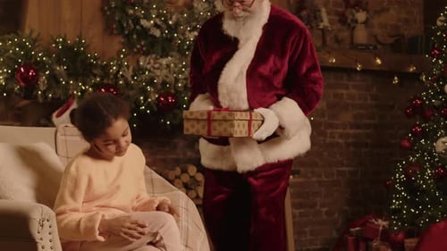 Girl Sitting in Armchair Waiting Christmas Gift Box from Santa Claus