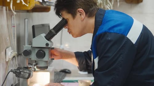 Person uses microscope in lab