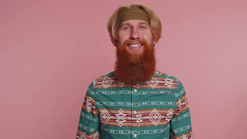 Alegre barbudo hippie hippie, ruivo, modelo em camisa estampada, sorrindo, olhando para a câmera