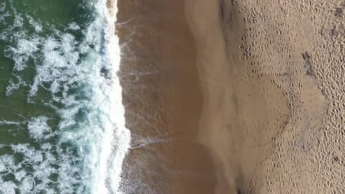 Aerial View of a Secluded Sandy Beach and Sea Waves by Drone