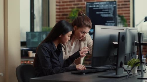 Software Development Team Compares Software Algorithms on Laptop Screen with Seated Workstation