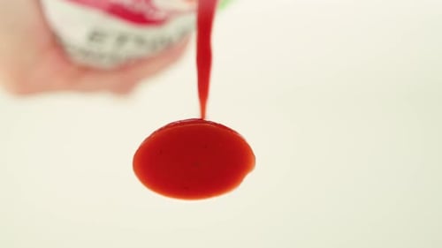 Homemade Strawberry Jam in a Jar on a Rustic Wooden Table Sauce Pouring Close Up Macro