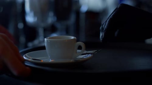 Close up of Waiters Hand Placing Coffee Cup