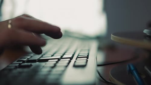 Person Hands Type on Computer Keyboard Sitting at Table