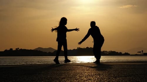 Silhouette of mother meeting child in street.