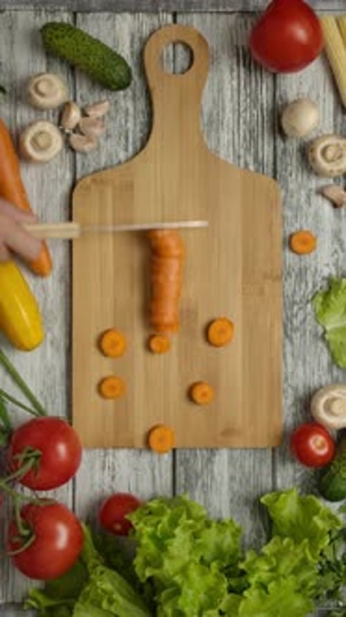 Vertical of Cook Moving Sliced Carrot with Knife