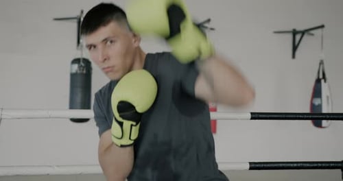 Man Boxing and Practicing Punching in Boxing Ring