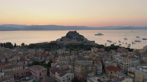 Vue aérienne du coucher du soleil sur la forteresse de Corfou, la ville et les yachts de luxe dans la mer Ionienne, Grèce
