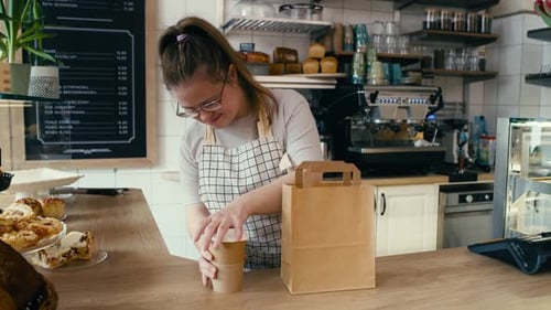 Young Woman Preparing Order in Sunny Cafe