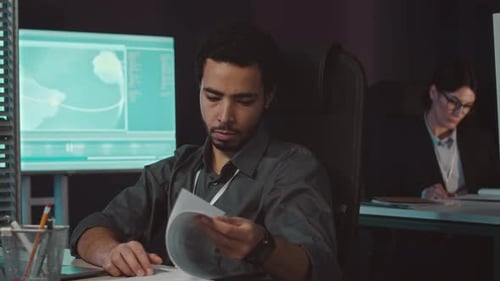 Cybersicherheitsmitarbeiter im Nahen Osten am Arbeitsplatz im dunklen Büro