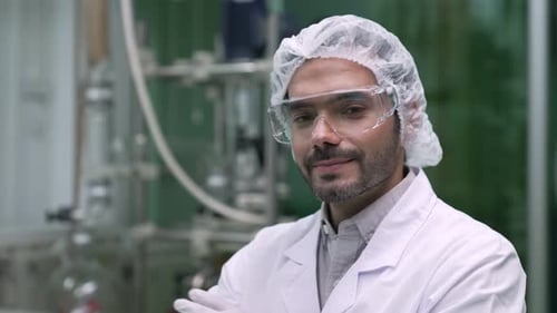 Man in Lab Coat Smiles Confidently in Laboratory