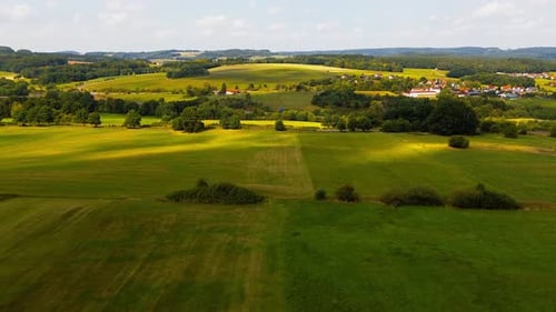 Scenic Countryside Landscape with Green Fields and Village in the Distance
