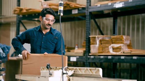 Man working with wood cutting machine in factory
