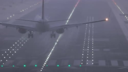 An airliner lands on a wet runway at San Diego International Airport after a rain storm in tricky cr