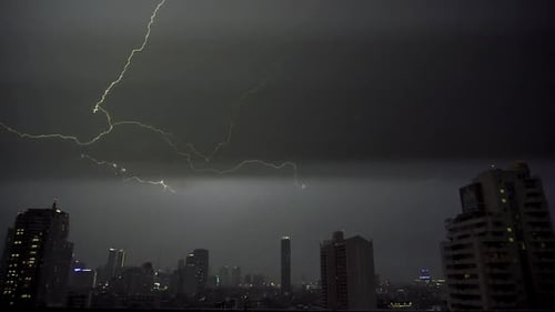 Lightning and rain in modern city center of Bangkok.