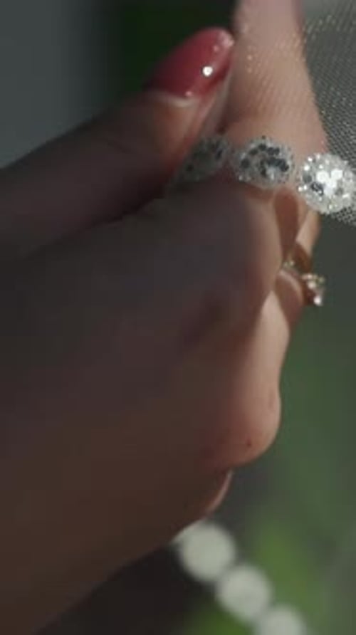 Woman Holding Veil Outside on Wedding Day