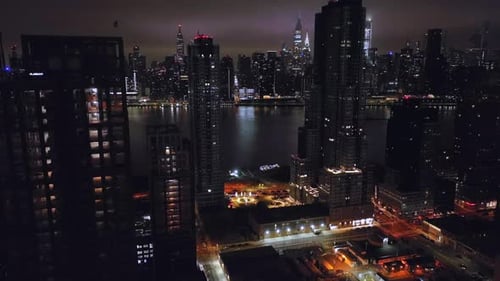An aerial view of the Eastside of New York City at night from Long Island City. The drone camera boo