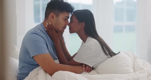 Intimate Young Couple Touching Foreheads in Bedroom