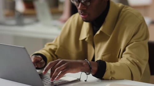 Concentrated African American Young Man Working on Laptop in Office