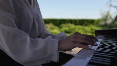 Woman plays Piano outside on a Sunny Day