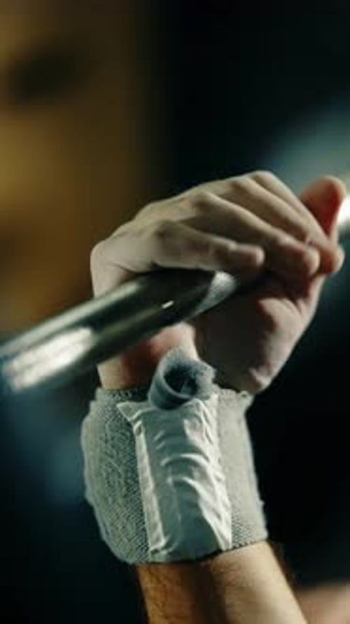 Closeup Sequence of an Athlete's Chalked Hands Approaching and Gripping a Textured Barbell