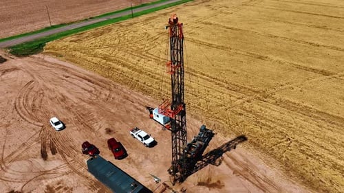 Pocos coches se paran junto al camión con la torre de perforación alta para perforar gas.