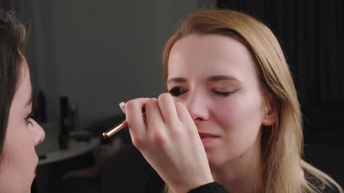 Makeup Artist Applying Makeup to Blonde Woman