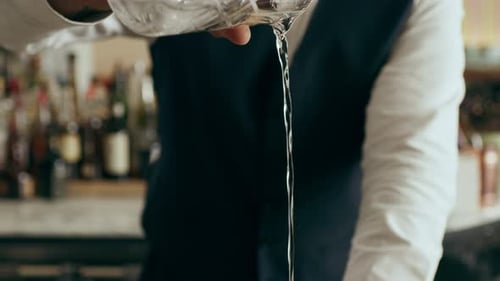 Bartender Prepares Elegant Cocktail with Clear Liquid and Ice