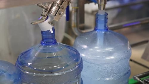 Quick filling of bottles with fresh water. Food factory production. Water supply at manufacture.