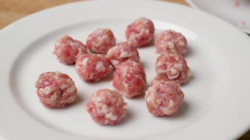 Raw Meatballs Piled on a Plate Ready to Cook
