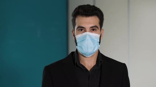 protection, contagion - young employee wearing the mask in the office