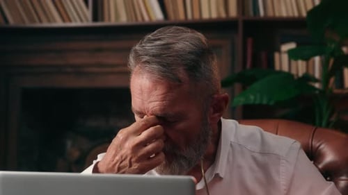 Man With Gray Hair Using Laptop Indoors