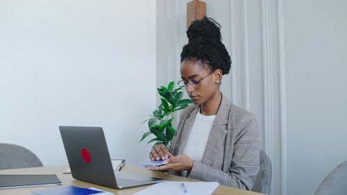 A Skilled Professional is Working Remotely on Her Sleek Laptop in a Modern Office Highlighting the