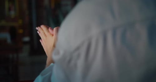 Woman praying to God with HOPE and FAITH in church. Close-up hands, religious girl in temple worship