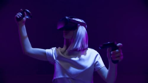 Woman Playing VR Game with Headset and Controllers