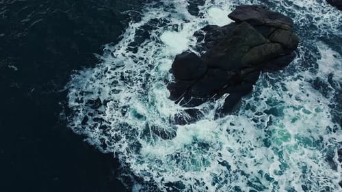 Top Down Abstract Aerial View of Ocean Waves Crashing on Rocky Shoreline