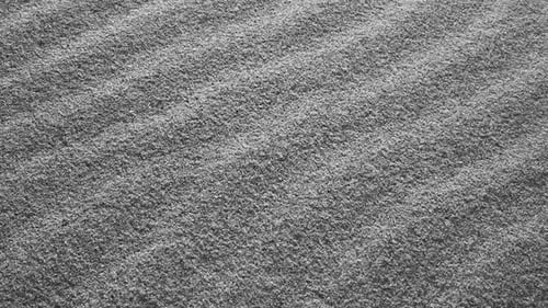 A Slow Motion Close Up View of Fine Shimmering Sand Grains Reflecting Light Creating a Sparkling