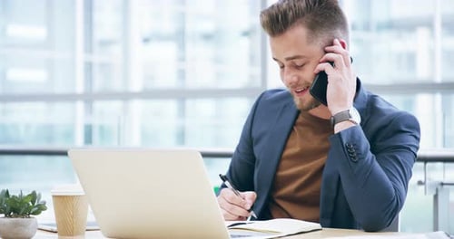 4k video footage of a handsome young businessman working on his laptop in the office