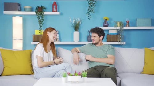 Young Couple Chatting on Couch in Colorful Living Room
